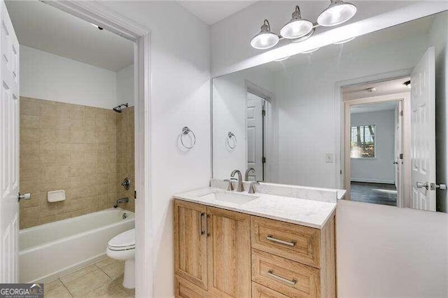 full bathroom featuring tile patterned flooring, vanity, toilet, and tiled shower / bath combo