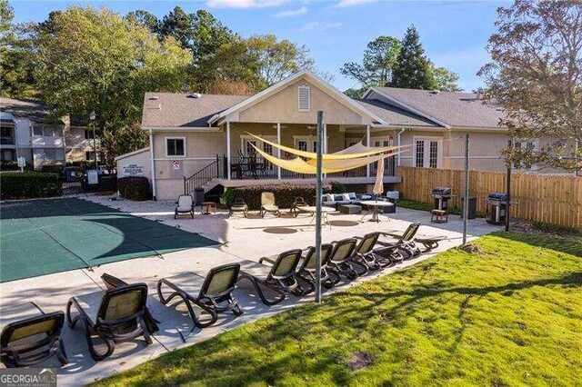 back of house with a yard, a patio, and a covered pool