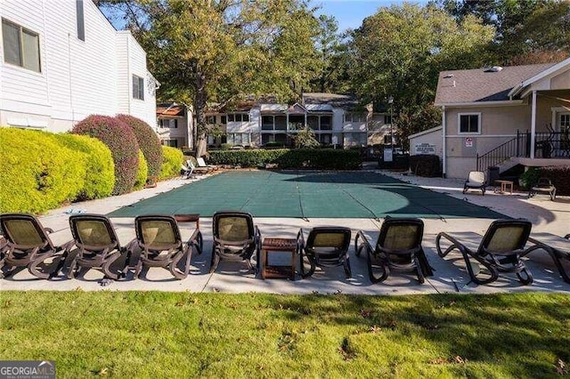 view of pool with a lawn and a patio area