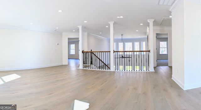 empty room with ornamental molding and light wood-type flooring