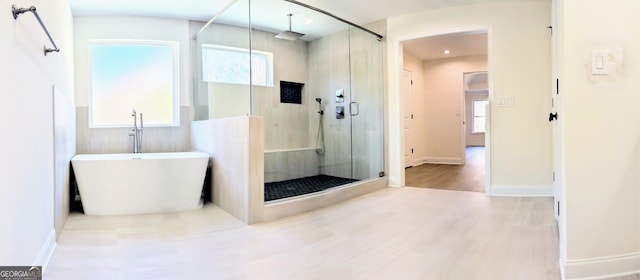 bathroom featuring wood-type flooring and separate shower and tub