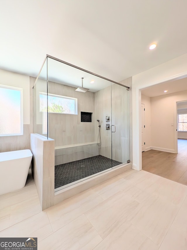 bathroom featuring hardwood / wood-style floors and independent shower and bath