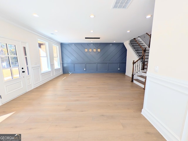 entrance foyer featuring light hardwood / wood-style flooring and ornamental molding