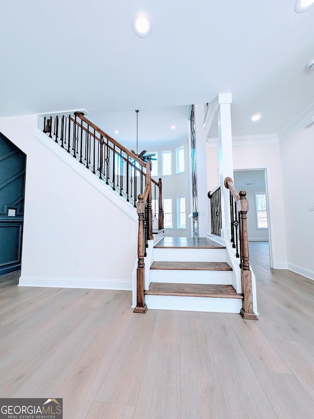 stairway featuring wood-type flooring and crown molding