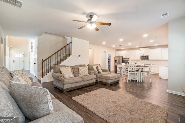 living room with ceiling fan and dark wood-type flooring