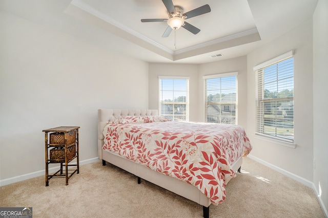 carpeted bedroom featuring a raised ceiling, ceiling fan, and crown molding