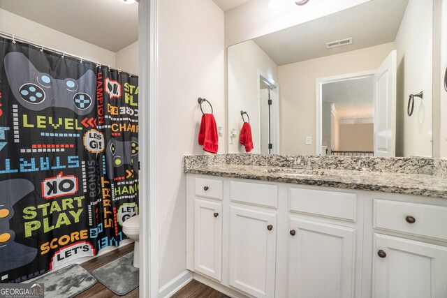 bathroom with hardwood / wood-style floors, vanity, and toilet