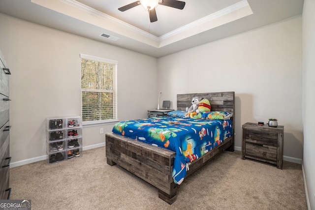 carpeted bedroom featuring a raised ceiling, ceiling fan, and crown molding