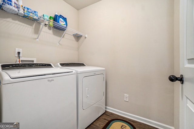 clothes washing area with washing machine and dryer and dark wood-type flooring