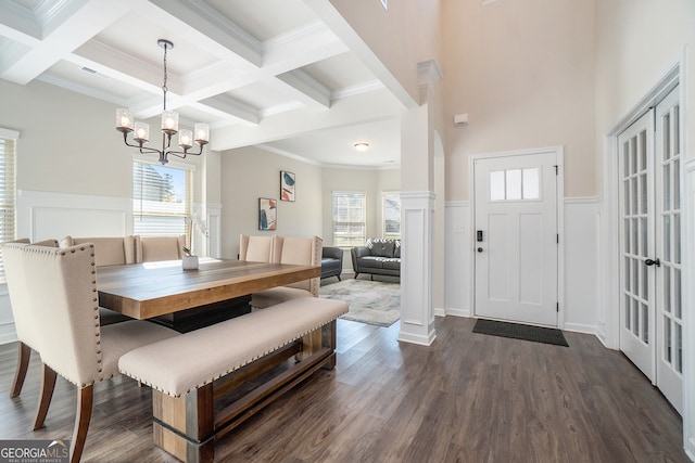 dining room featuring beam ceiling, dark hardwood / wood-style floors, an inviting chandelier, and a healthy amount of sunlight