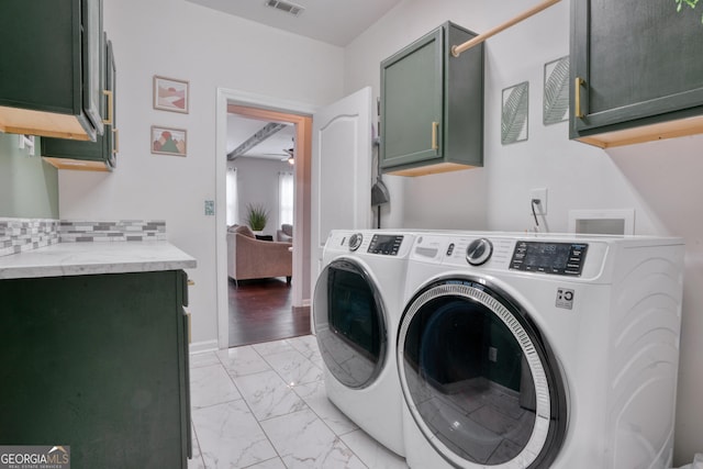 clothes washing area featuring light hardwood / wood-style floors, cabinets, and independent washer and dryer