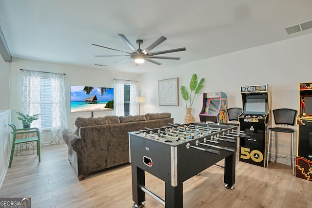 rec room with light wood-type flooring and ceiling fan