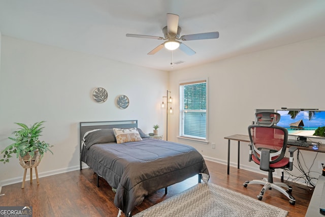 bedroom with dark hardwood / wood-style flooring and ceiling fan