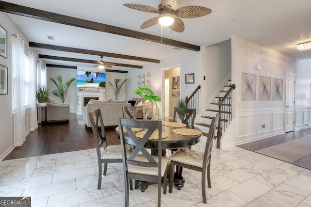 dining space with beamed ceiling, light hardwood / wood-style flooring, and ceiling fan