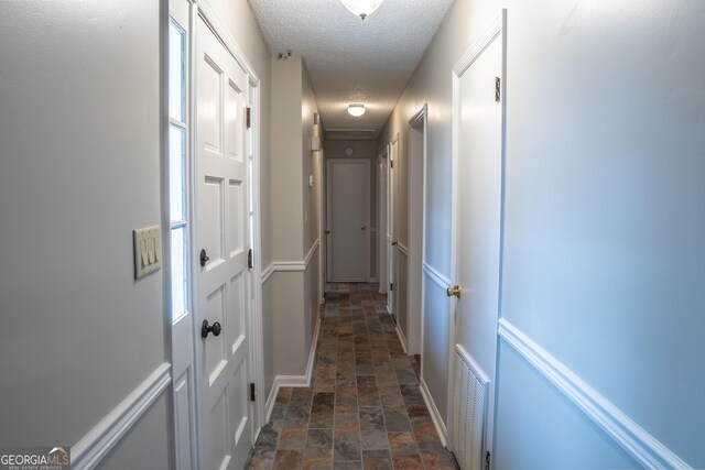 spare room with a textured ceiling, carpet floors, and ceiling fan