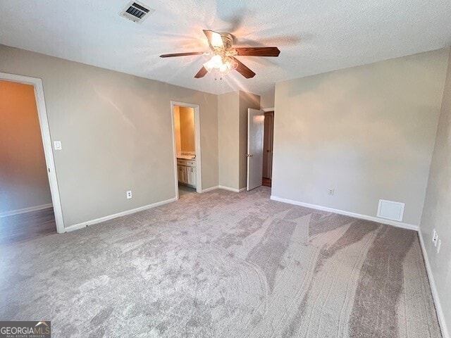 carpeted spare room featuring a textured ceiling and ceiling fan