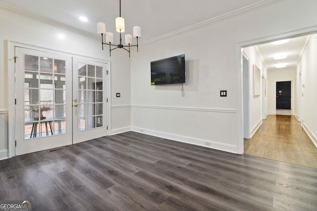 unfurnished dining area with dark hardwood / wood-style flooring, ornamental molding, a chandelier, and french doors