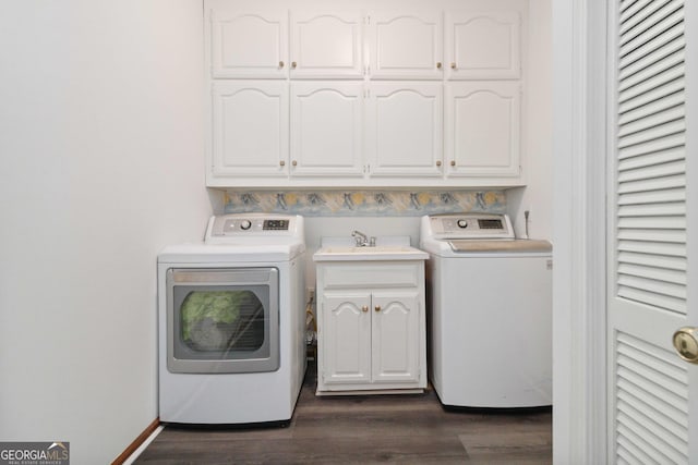 washroom featuring washing machine and dryer, dark hardwood / wood-style floors, and cabinets