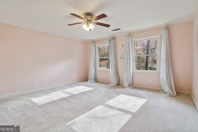 spare room featuring crown molding, light colored carpet, and ceiling fan