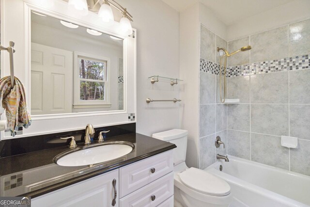 full bathroom featuring toilet, vanity, and tiled shower / bath combo