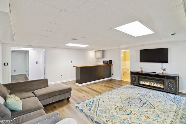 living room featuring hardwood / wood-style floors and a drop ceiling