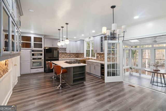 living room featuring beamed ceiling, dark hardwood / wood-style flooring, crown molding, and a healthy amount of sunlight