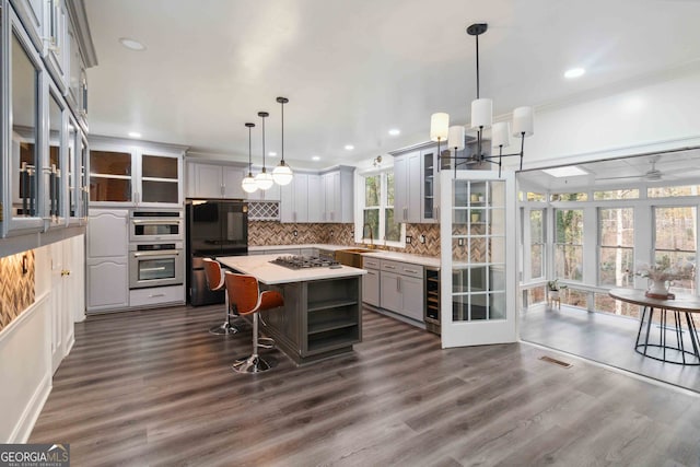 kitchen featuring pendant lighting, a center island, gray cabinets, and dark hardwood / wood-style floors