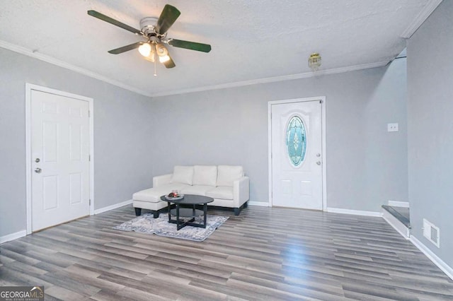 entryway with a textured ceiling, hardwood / wood-style flooring, ceiling fan, and ornamental molding