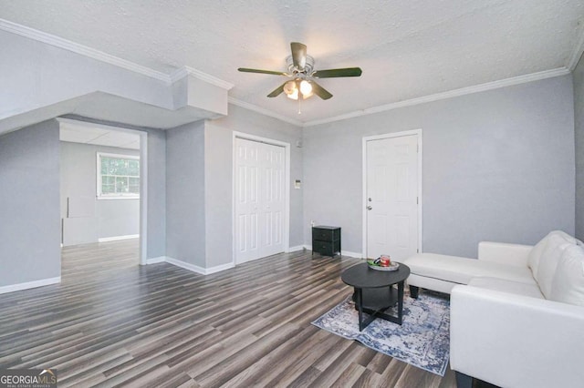 living room with hardwood / wood-style flooring, ceiling fan, crown molding, and a textured ceiling