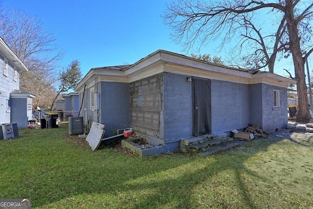 view of side of property with central AC and a lawn