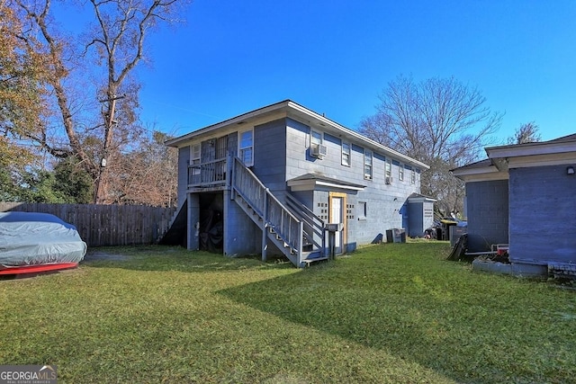 rear view of property with central AC and a lawn