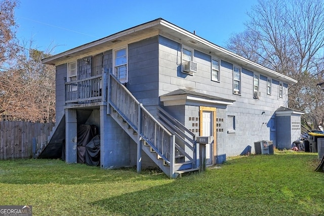 rear view of house with cooling unit and a yard