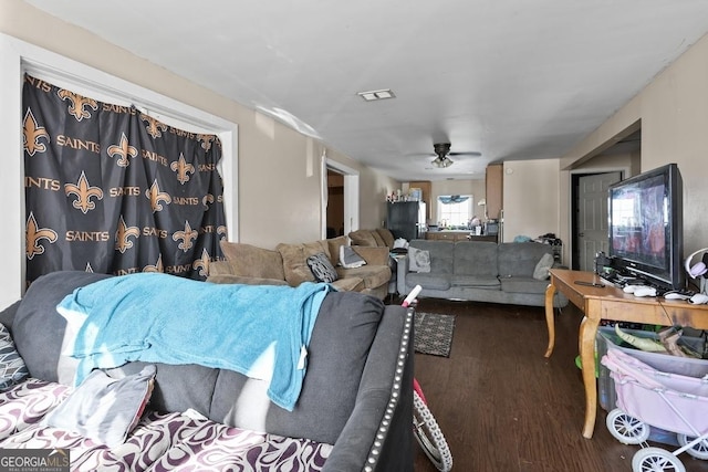 living room featuring ceiling fan and dark wood-type flooring