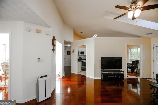 living room featuring dark hardwood / wood-style floors, ceiling fan, and vaulted ceiling