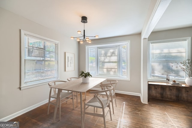 dining space featuring dark hardwood / wood-style flooring and an inviting chandelier