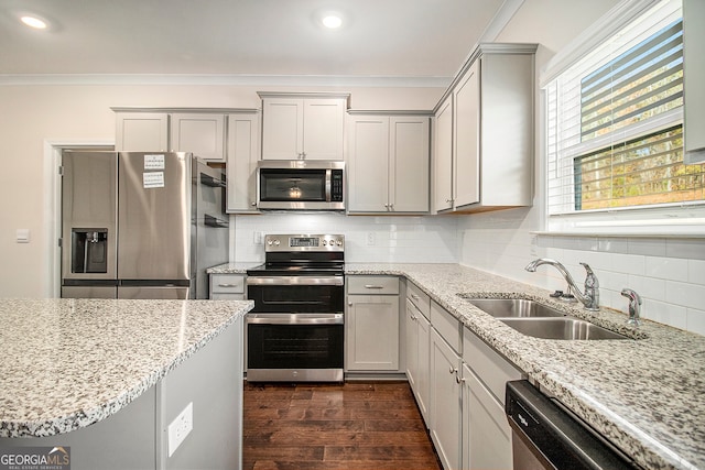 kitchen with sink, stainless steel appliances, light stone counters, dark hardwood / wood-style flooring, and decorative backsplash