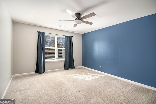 carpeted spare room with ceiling fan