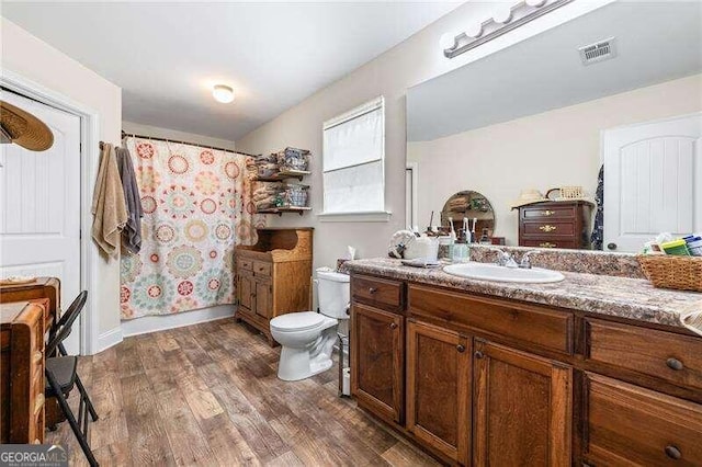 bathroom with hardwood / wood-style floors, vanity, and toilet