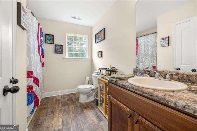 bathroom with toilet, vanity, and hardwood / wood-style flooring