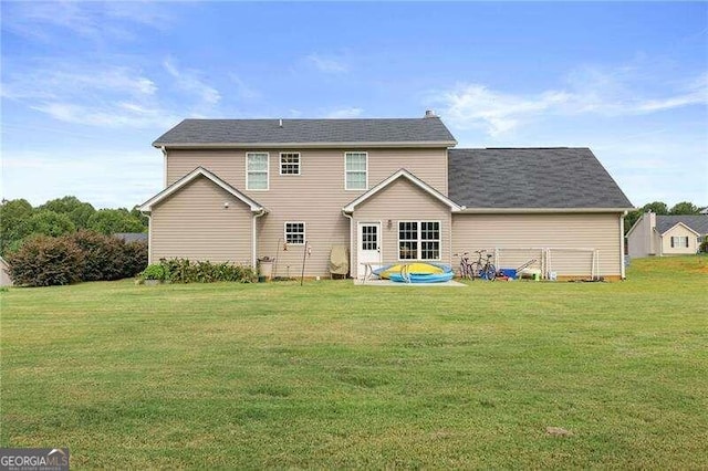 rear view of property with a lawn