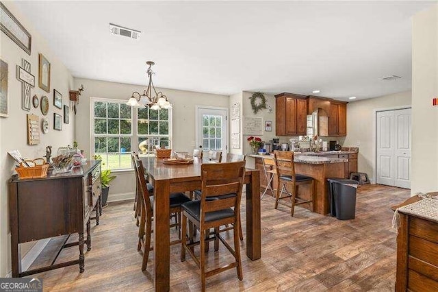 dining room with dark hardwood / wood-style floors and an inviting chandelier