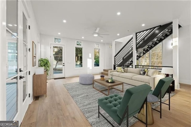 living room featuring ceiling fan, french doors, and light hardwood / wood-style floors