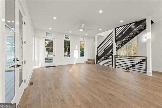 unfurnished living room with french doors, light hardwood / wood-style flooring, ceiling fan, and a healthy amount of sunlight