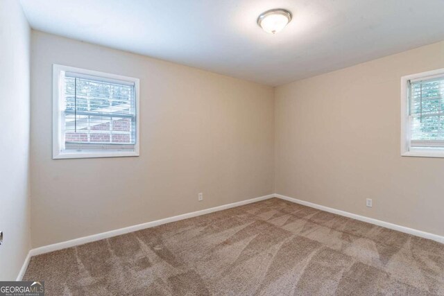 carpeted spare room featuring plenty of natural light