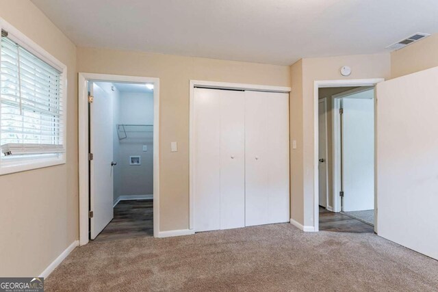 unfurnished bedroom featuring carpet and a closet