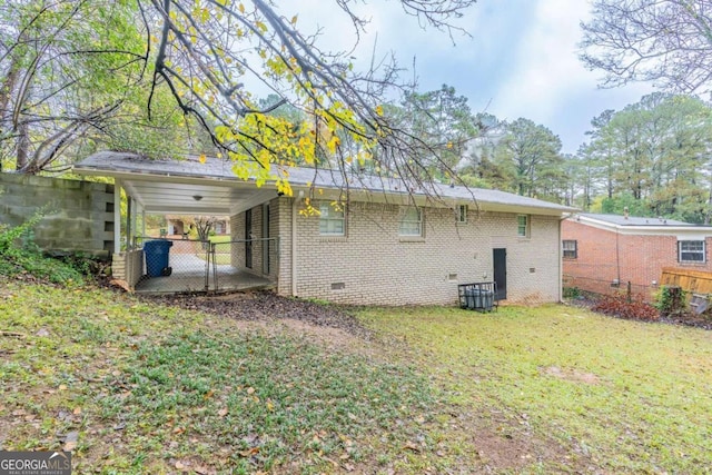 rear view of property featuring a carport and a lawn