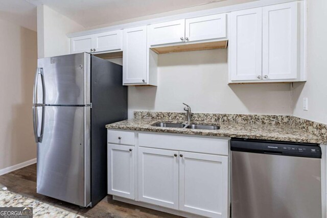 kitchen with white cabinets, sink, light stone countertops, and stainless steel appliances