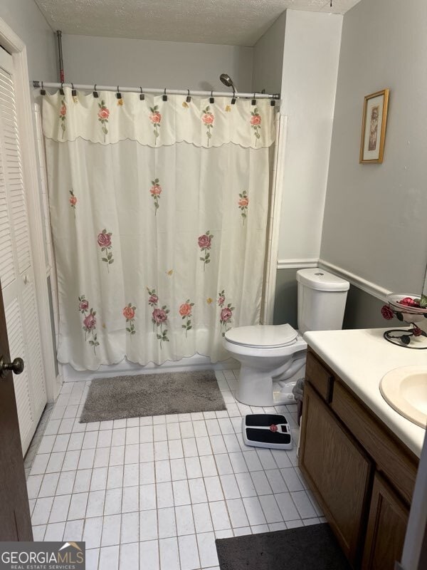 full bathroom featuring tile patterned flooring, a textured ceiling, toilet, and shower / bathtub combination with curtain