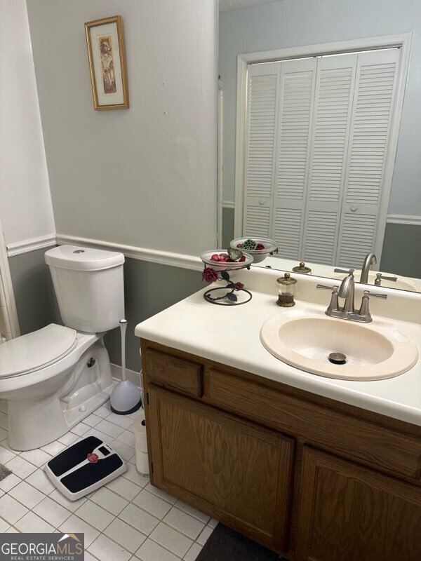 bathroom featuring tile patterned flooring, vanity, and toilet