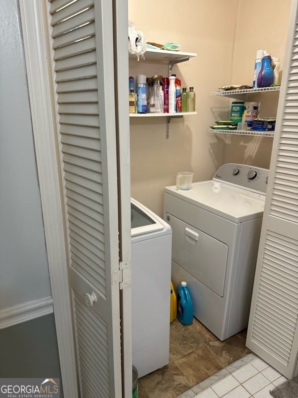 laundry room with washer and dryer and light tile patterned floors